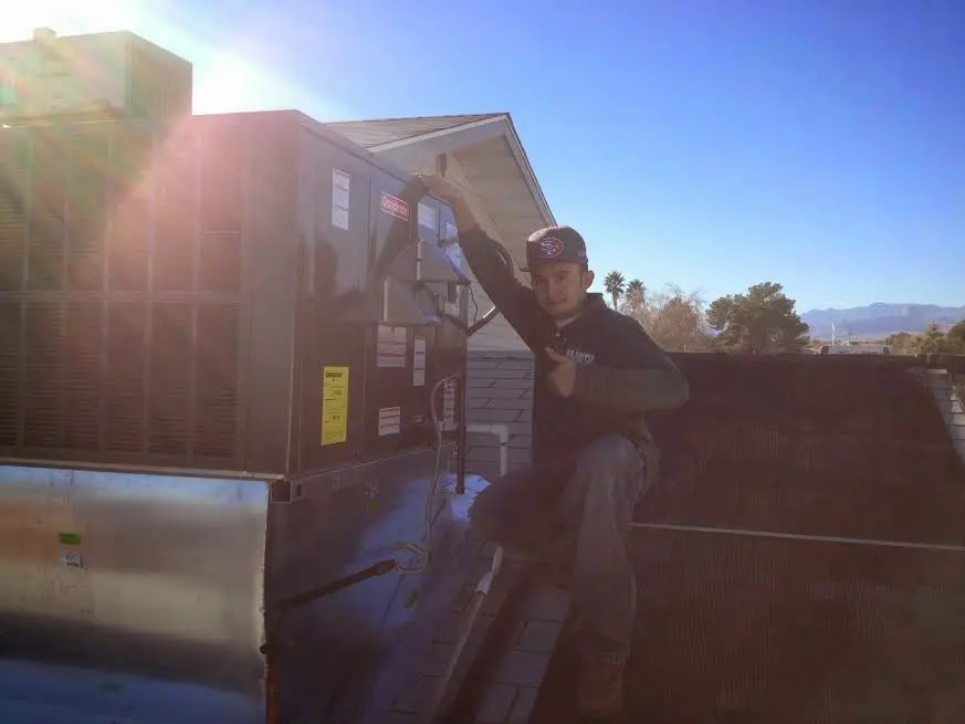 HVAC technician performing HVAC Inspection on a rooftop unit in Irving